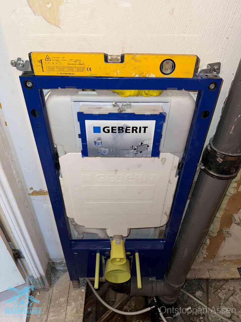 Een Geberit inbouwreservoir met frame voor een hangtoilet tegen de wand, met de afvoerbocht naar de vloer, kenmerkend voor een verstopt hangtoilet in Assen