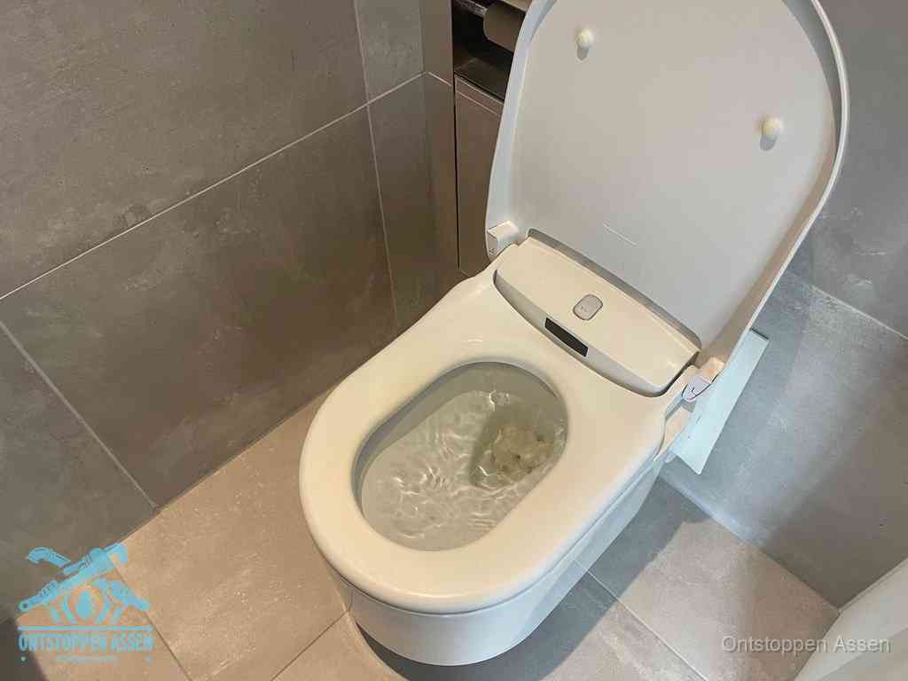 Een toiletpot vol troebel water met drijvend papier en restanten, de meest voorkomende oorzaak van een verstopte wc in Assen
