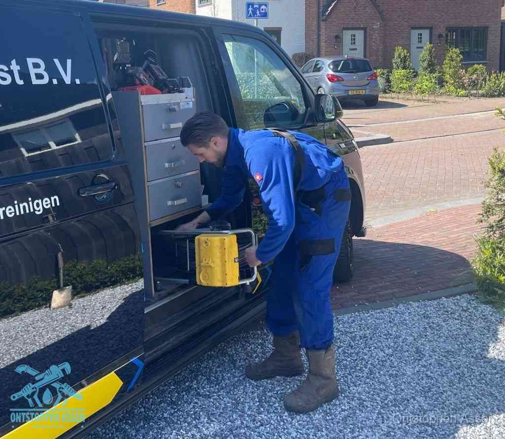 Een monteur pakt apparatuur uit de bedrijfsbus voor service aan huis, het moment om een professional in te schakelen in Assen